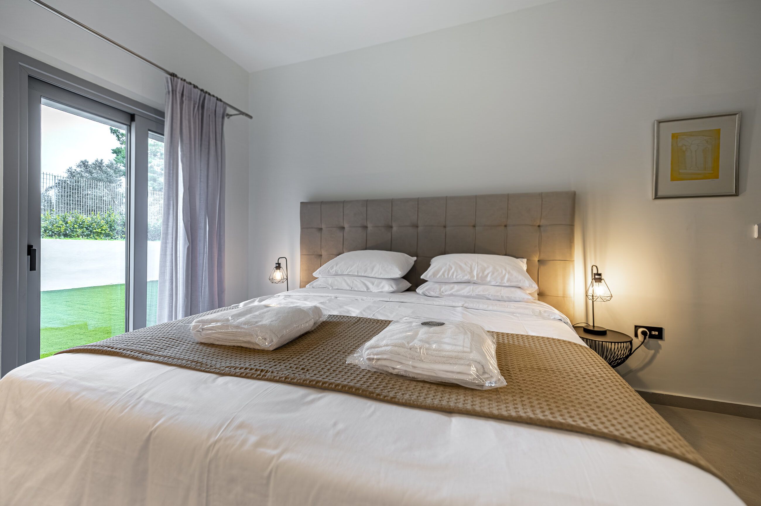 Master suite of the Athens Airport Stay apartment in daylight, double bed with premium linens