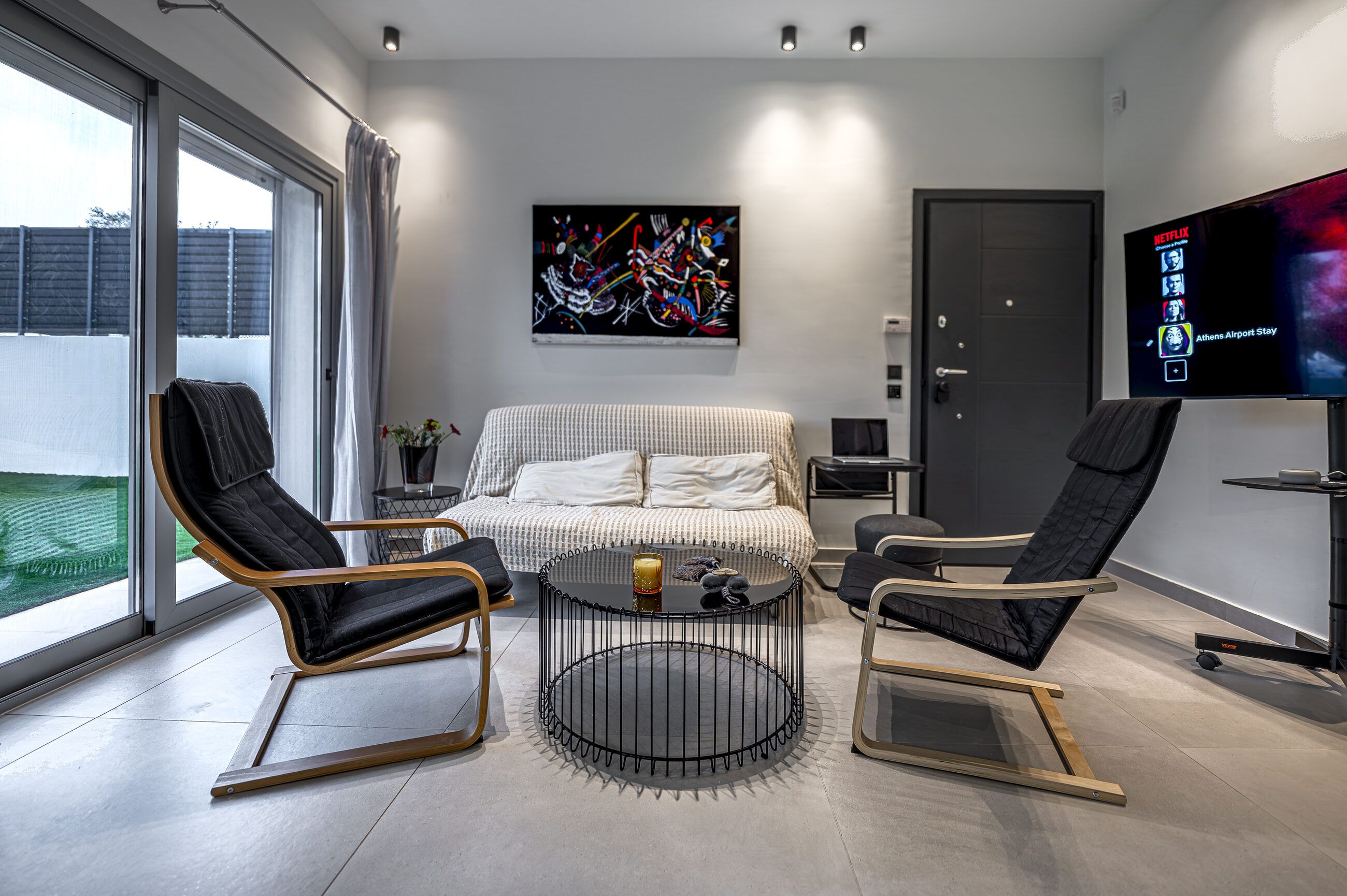 Living area from the hallway, with the sofa bed made up, smart TV and doors to the garden